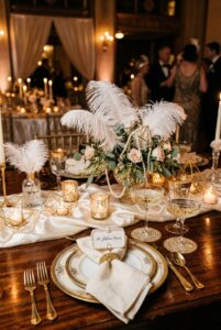1920s Art Deco vintage wedding tablescape with gold geometric accents, coupe glasses, feather centerpieces, and ivory linens — portrait 2:3