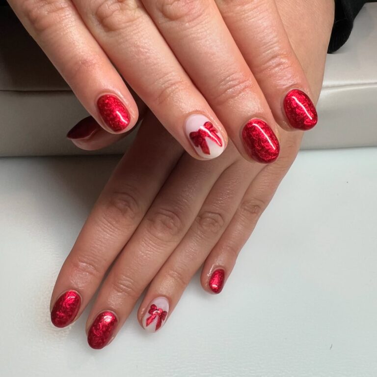 Alt text: Metallic red nails with chrome reflective finish on a bride's hand, bold modern bridal manicure, evening wedding look