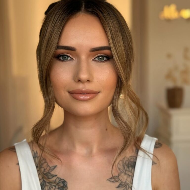 Alt text: Bride with sheer skin-tint foundation and liquid highlighter on cheekbones, barely-there glowy base, editorial bridal portrait