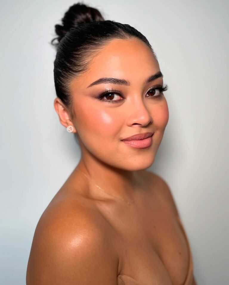 Alt text: Bride with barely-there soft brown winged liner on upper lash line, subtle eye definition, fresh glowy bridal makeup, close-up