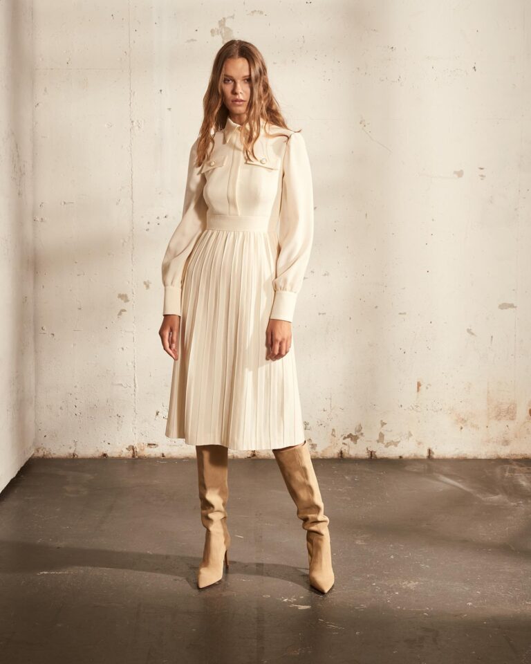 Alt text: Bride in a white pleated midi dress at courthouse wedding, graceful and textured bridal look