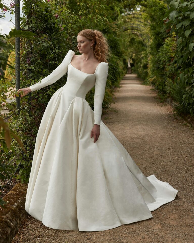 Alt text: Bride wearing a white pleated skirt wedding dress at city hall, graceful bridal look, architectural backdrop