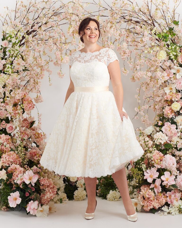 Bride in short white lace elopement dress, above-the-knee length, romantic bridal detail